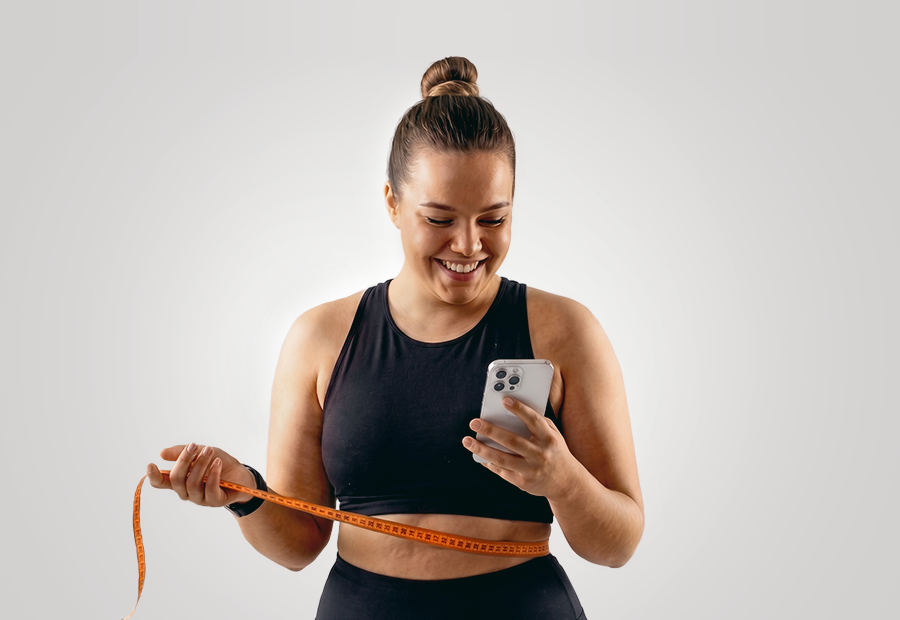SCANECA 3D-Körperanalyse: Frau bewertet Fitnessfortschritte mit Smartphone und Maßband.
